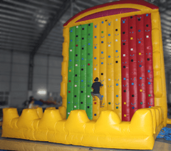 Colorful themed climbing wall by Soft Summits featuring various handholds and footholds for indoor rock climbing fun.