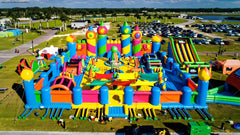 Colorful inflatable obstacle course by Soft Summits featuring slides, tunnels, and climbing areas for outdoor fun.