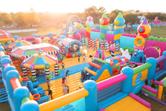 Colorful themed inflatable obstacle course by Soft Summits with slides, tunnels, and climbing areas for kids' outdoor fun.