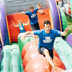 A lively scene of people enjoying Soft Summits' commercial-size inflatable obstacle course, filled with thrilling challenges and fun activities.