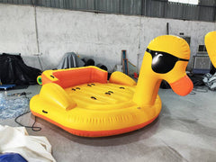 Large inflatable 5-seater duck boat by Soft Summits, shown at warehouse, designed for towing and giant pool fun.
