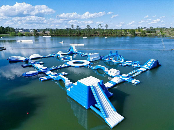 Large inflatable water park by Soft Summits, featuring slides, climbing areas, and water features for outdoor recreation.