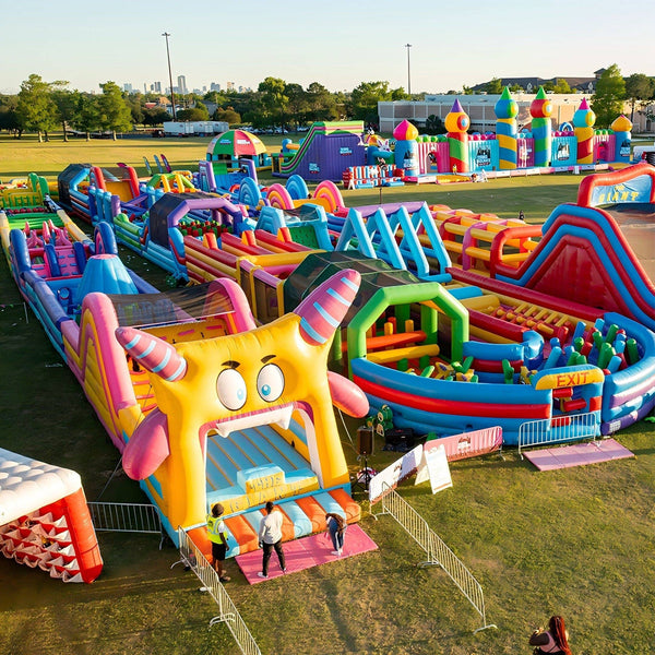 Colorful Soft Summits themed inflatable obstacle course with slides and tunnels for outdoor fun and active play.