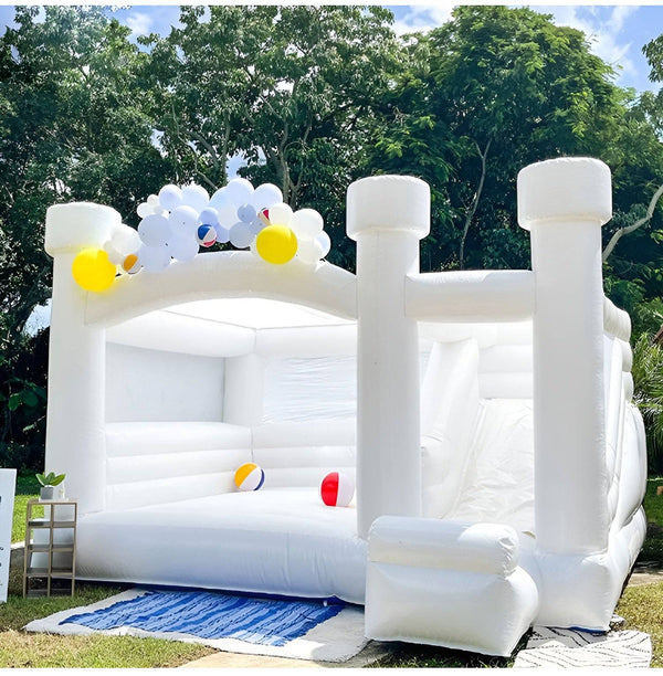 Soft Summits inflatable bounce house with slide and balloons, designed for wedding parties and outdoor celebrations.